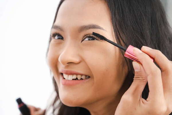 Asiático chica tocando negro delineador de ojos a su párpado —  Fotos de Stock