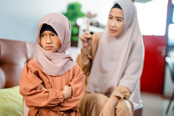 Muslim naštvaný asijské matka sedí s malou dcerou — Stock fotografie