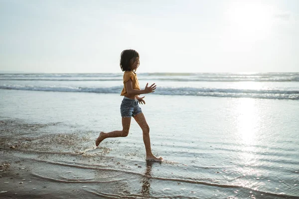 Kinder spielen am Strand und genießen den Sonnenuntergang — Stockfoto