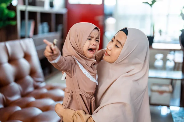 Muzułmańska matka z hidżabskim szalikiem pociesza swoją płaczącą córeczkę — Zdjęcie stockowe