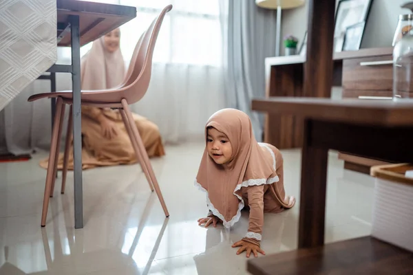 Bayi perempuan Muslim yang lucu merangkak ini hijab di rumah — Stok Foto