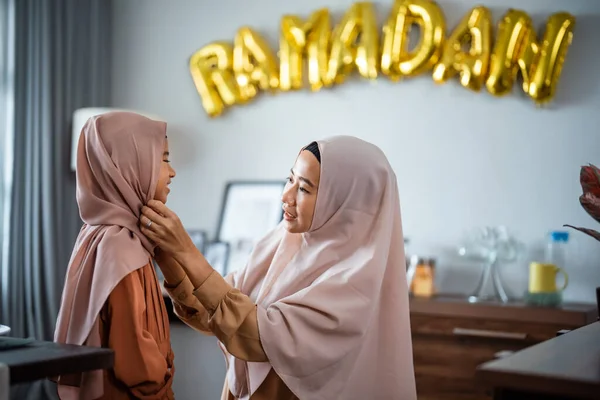 Musulmana madre fissaggio suo dauhgter velo su ramadan — Foto Stock