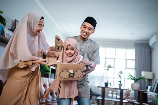 Genitore musulmano giocare aereo di cartone con la loro adorabile figlia giovane — Foto Stock