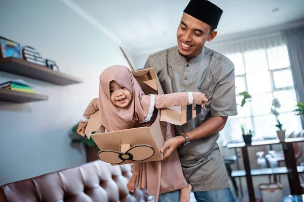 Chica con hijab jugando con avión de cartón con papá — Foto de Stock