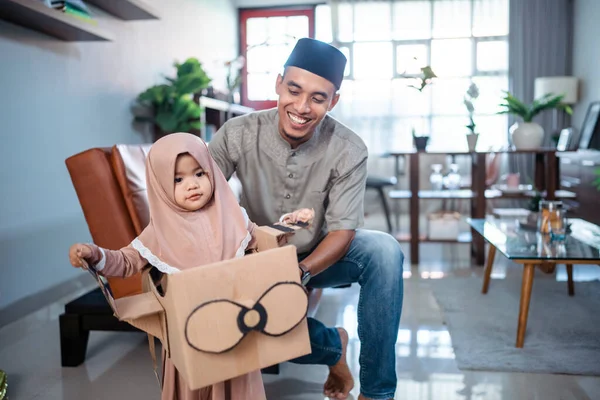 Menina com hijab brincando com avião de papelão com o pai — Fotografia de Stock