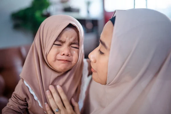 Musulmana madre con hijab bufanda reconfortar a su llorando niña — Foto de Stock