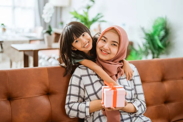 Bela mãe e filha com caixa de presente sorrindo para a câmera — Fotografia de Stock