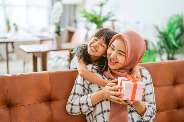 Hija pequeña dando una caja de regalo sorpresa a su madre — Foto de Stock