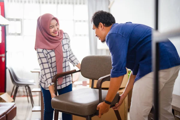 Musulmán joven pareja moviendo nueva silla en su nuevo hogar —  Fotos de Stock