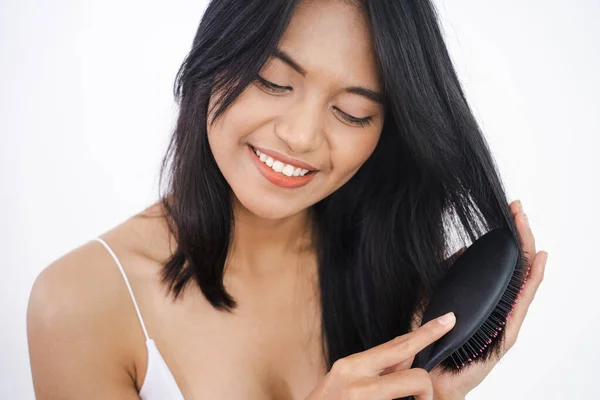 Feliz atraente asiático mulher escova seu cabelo — Fotografia de Stock