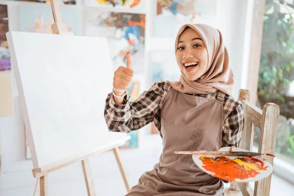 Musulmano asiatico femmina artista mostrando pollice su — Foto Stock