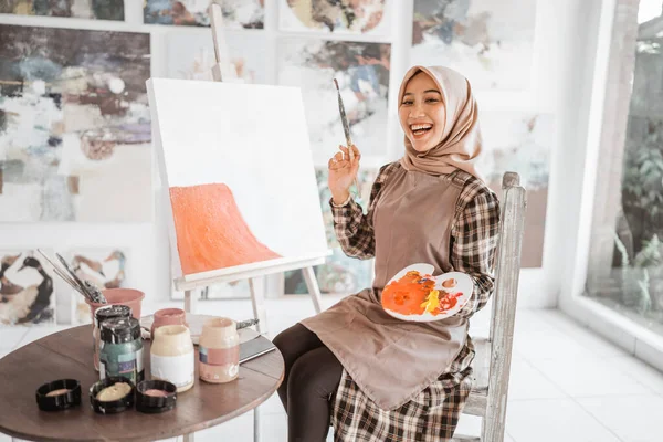 Μουσουλμάνα ζωγράφος ζωγραφίζει σε καμβά στο εργαστήριό της — Φωτογραφία Αρχείου