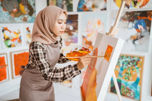 Concentrado asiático musulmán mujer artista pintura en lienzo —  Fotos de Stock
