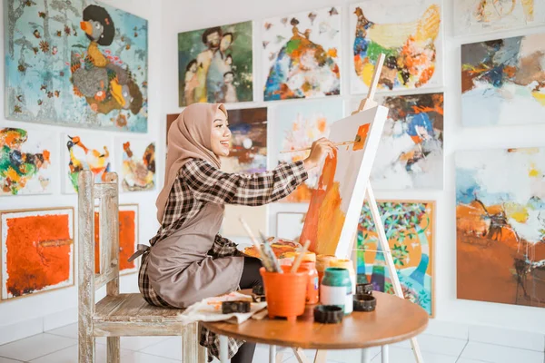 Мусульманская азиатская художница, рисующая на холсте — стоковое фото