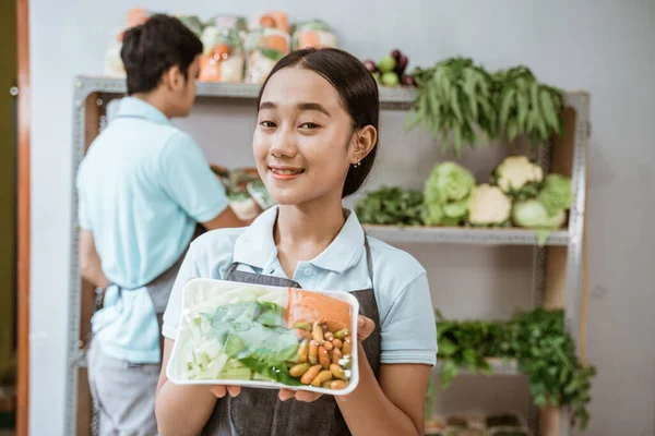 野菜を包んだ笑顔の野菜販売の女の子 — ストック写真