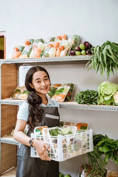 Schattig meisje met een schort vol verse groenten — Stockfoto