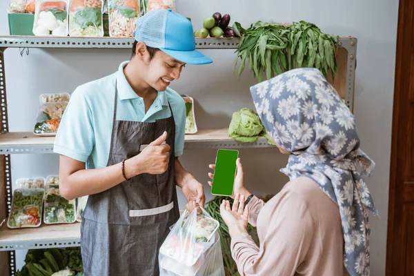 Klant toont mobiele telefoon scherm tijdens het maken van niet-contante betaling — Stockfoto