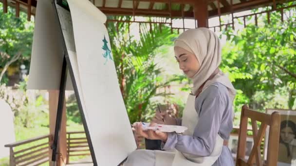 Muslim asian female artist painting on canvas — Stock Video