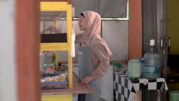 Muslimische asiatische Frau bereitet ihren Essensstand vor — Stockvideo