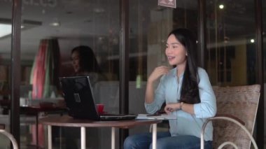 Toplantı sırasında dizüstü bilgisayar ve pano kullanarak çalışan serbest Asyalı kadın