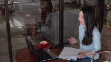 Çevrimiçi konferans sırasında laptop ve pano kullanan serbest çalışan kadın