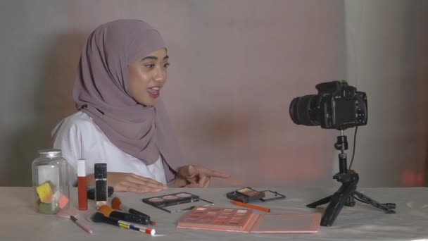 Asiático muçulmano mulher beleza blogger tutorial por sopro em pó maquiagem na bochecha — Vídeo de Stock