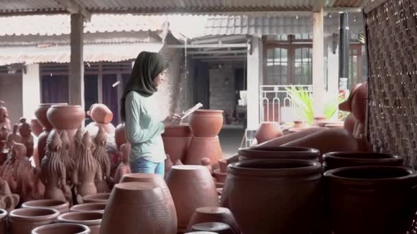 Mujer de negocios velada mirando cerámica mientras usa una almohadilla — Vídeo de stock
