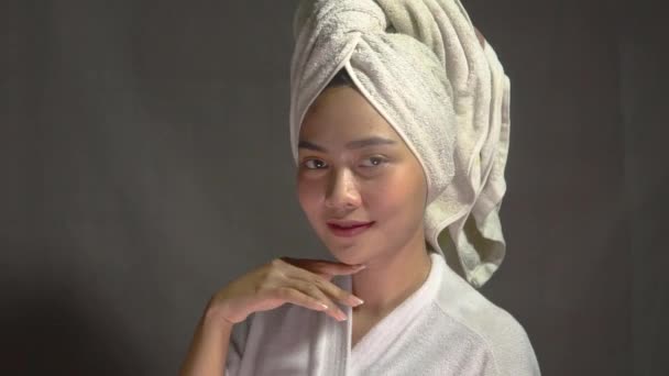 Atractiva chica con toalla de baño en la cabeza sonriendo con la mano sosteniendo la barbilla — Vídeo de stock