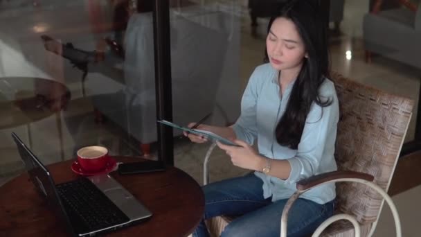 Toplantı sırasında dizüstü bilgisayar ve pano kullanarak çalışan serbest Asyalı kadın — Stok video