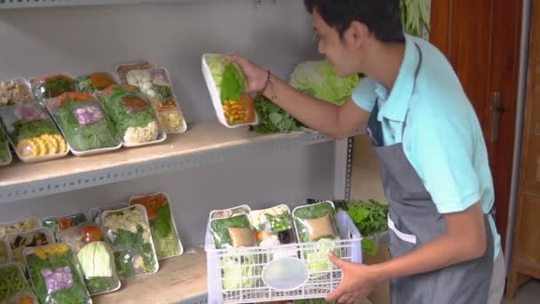 Asiatico maschio venditore a la sua negozio organizzazione il produck su scaffale — Video Stock