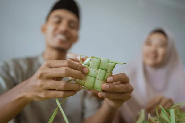 Musulmán pareja asiático haciendo ketupat arroz pastel en casa usando palma hoja —  Fotos de Stock