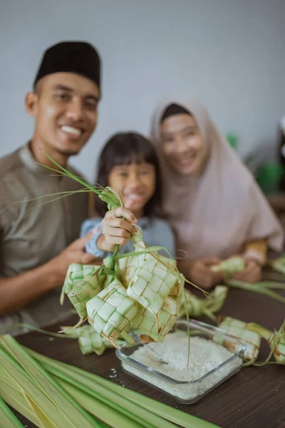 Anak dengan orang tuanya membuat ketupat di rumah — Stok Foto