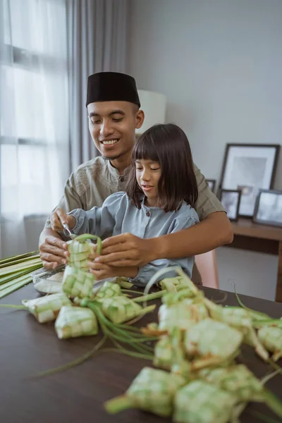 Padre e hija haciendo ketupat juntos en casa —  Fotos de Stock
