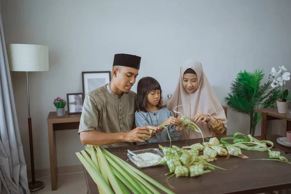 Anak dengan orang tuanya membuat ketupat di rumah — Stok Foto