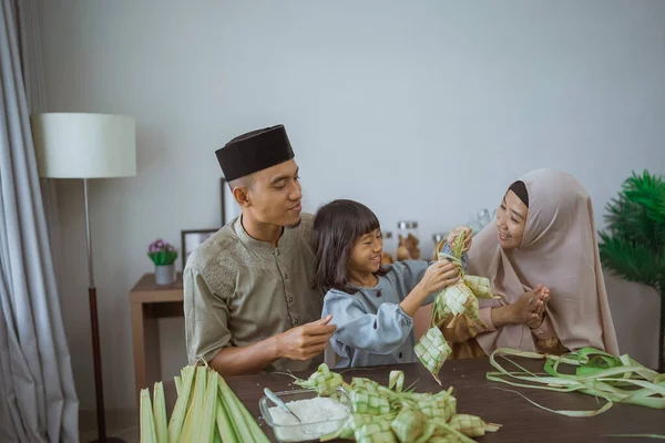 Çocuk ve ailesi evde ketupat yapıyor. — Stok fotoğraf