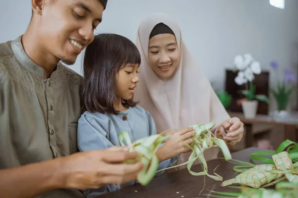 Çocuk ve ailesi evde ketupat yapıyor. — Stok fotoğraf