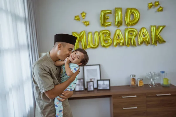 Muslim ayah dan anak berpelukan dengan dekorasi eid mubarak — Stok Foto