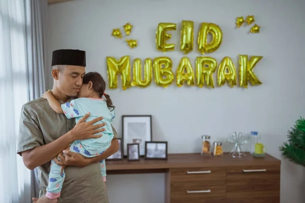 Muslim ayah dan anak berpelukan dengan dekorasi eid mubarak — Stok Foto