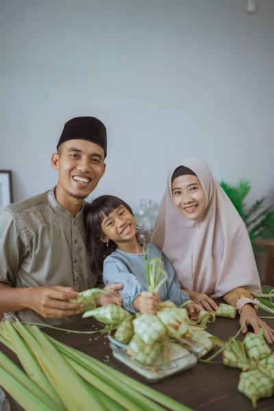 Anak dengan orang tuanya membuat ketupat di rumah — Stok Foto