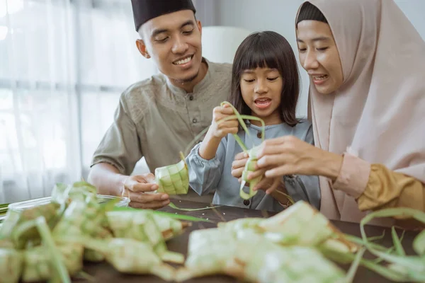 Παιδί με τους γονείς της να κάνουν ένα ketupat στο σπίτι — Φωτογραφία Αρχείου