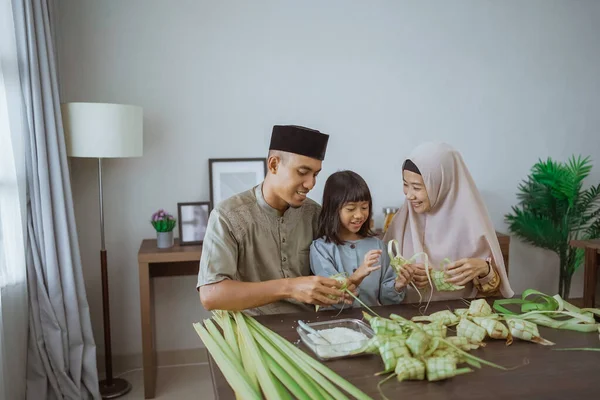 Muslim asian family making ketupat for eid mubarak together — Stock Photo, Image