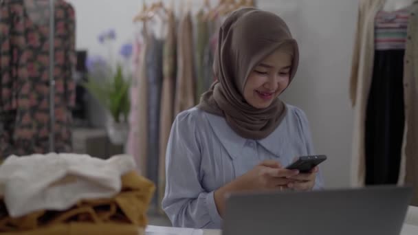 Donne d'affari musulmane che utilizzano il telefono cellulare che lavorano nel suo laboratorio — Video Stock