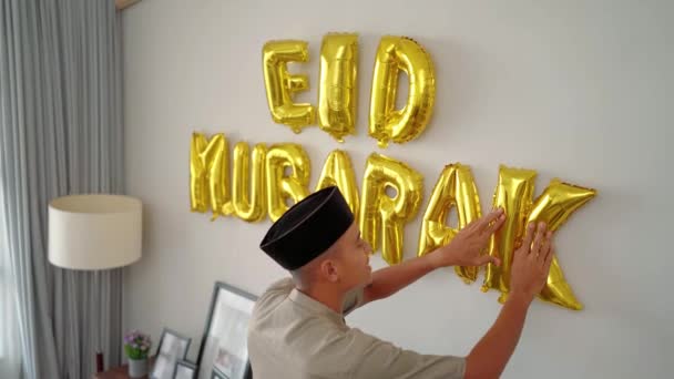 Muslim αρσενικό διακόσμηση του σπιτιού του με eid mubarak κείμενο — Αρχείο Βίντεο