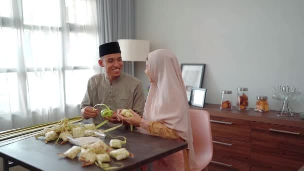 Muslim ζευγάρι ασιατική καθιστώντας κετουπάτ κέικ ρυζιού στο σπίτι χρησιμοποιώντας φύλλα φοίνικα — Αρχείο Βίντεο