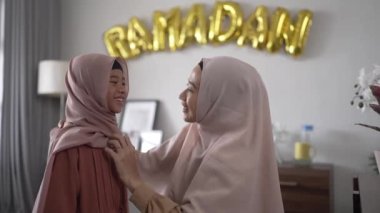 Müslüman anne, Ramazan 'da kızının başörtüsünü düzeltiyor.