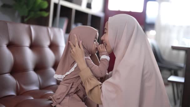 Moeder en dochter met hijab die samen een snack eten — Stockvideo