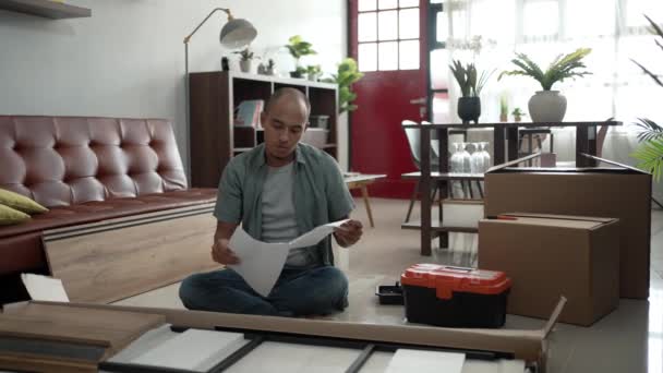 Joven asiático macho montaje muebles por sí mismo — Vídeos de Stock