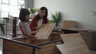 Anne ve kızı New Home 'da mobilya montajında.