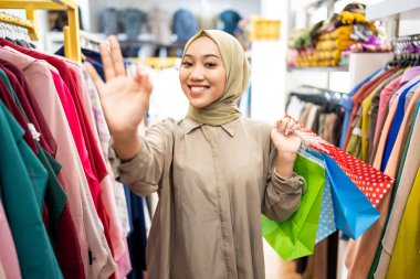 Butik dükkanında peçeli bir kadın var.