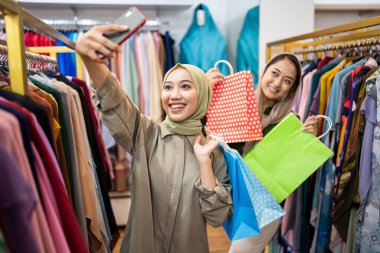 Müslüman kadın yürüyor ve alışveriş çantası tutuyor.